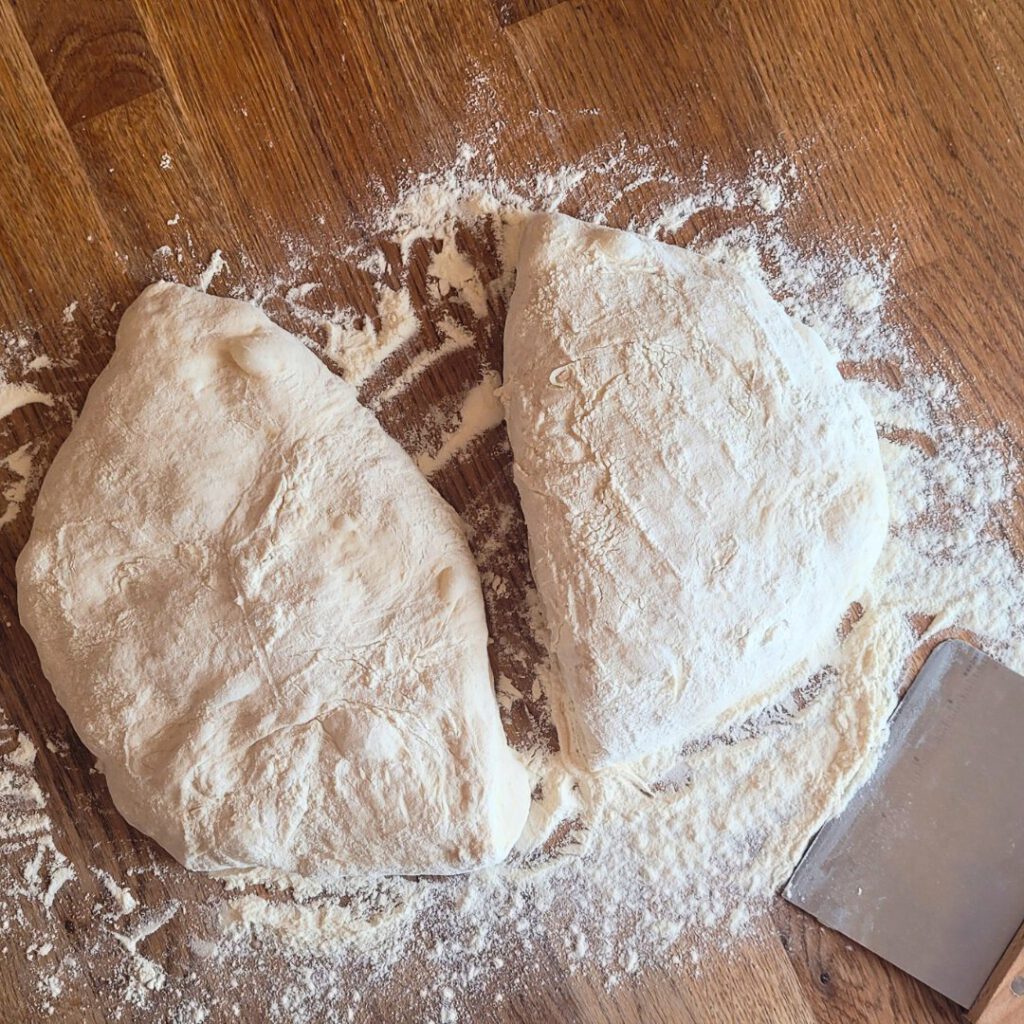 Carefully transfer the dough to a floured work surface and cut into two equal pieces using a dough scraper.