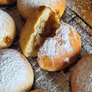 Die abgekühlten Krapfen mit einem Messer einstechen. Marmelade (oder eine andere Füllung) in eine Spritztülle füllen und die Krapfen befüllen. Anschließend die Berliner mit Puderzucker bestreuen.